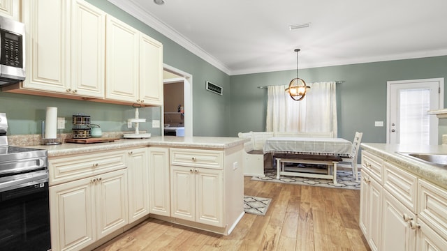 kitchen with hanging light fixtures, light wood-type flooring, ornamental molding, stainless steel appliances, and cream cabinets