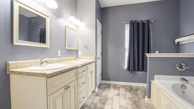 bathroom featuring vanity, a bath, and a wealth of natural light