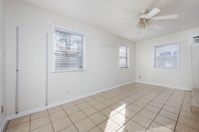 empty room with ceiling fan, light tile patterned floors, and baseboards