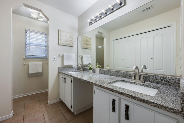 bathroom with double vanity, tile patterned flooring, a sink, and visible vents