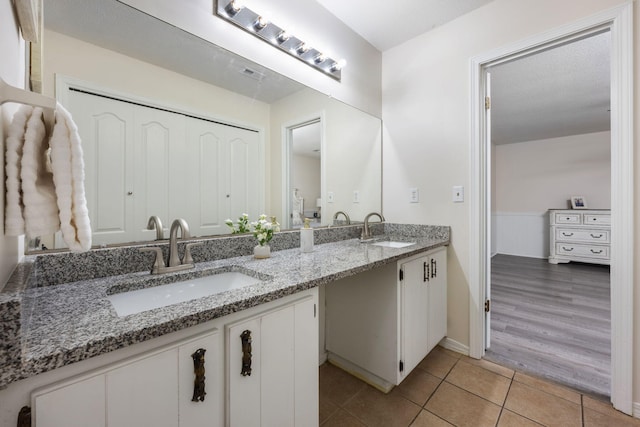 full bathroom featuring double vanity, tile patterned flooring, and a sink