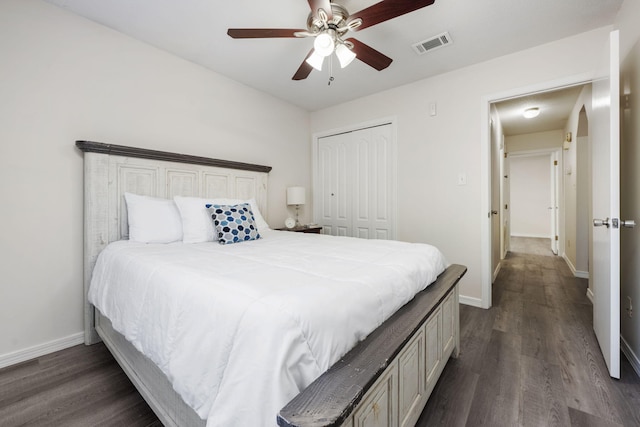 bedroom featuring a closet, dark wood-style flooring, visible vents, and baseboards