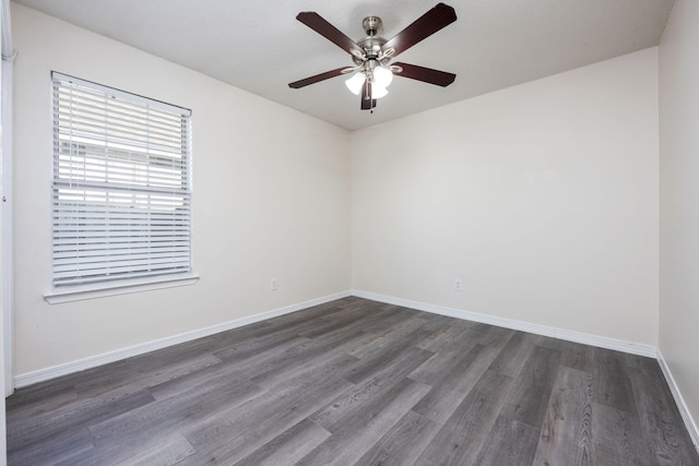 empty room with dark wood-style floors, ceiling fan, and baseboards