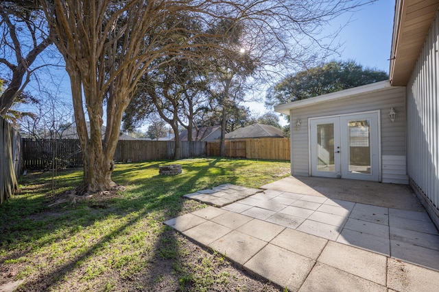 view of yard with french doors, an outdoor fire pit, a patio area, and a fenced backyard