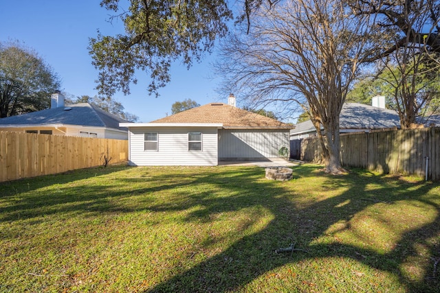 back of property with a yard and a fenced backyard