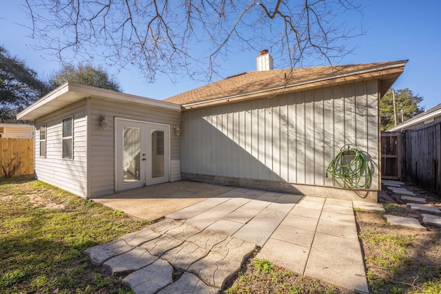 rear view of property featuring a patio, french doors, a chimney, and fence