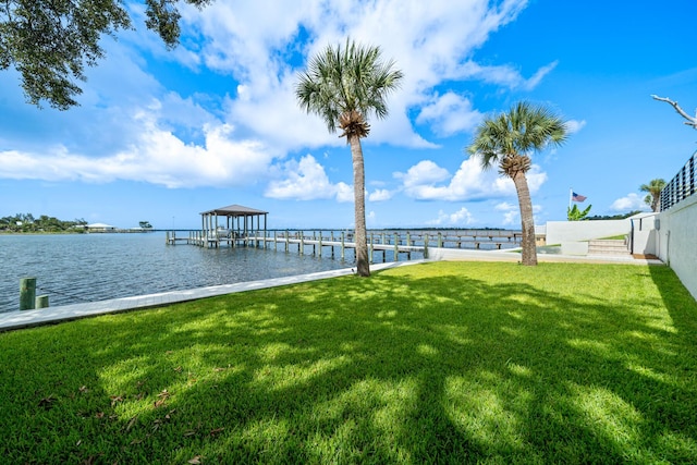 dock area with a lawn and a water view