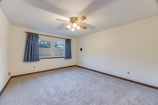 carpeted spare room featuring ceiling fan and a textured ceiling