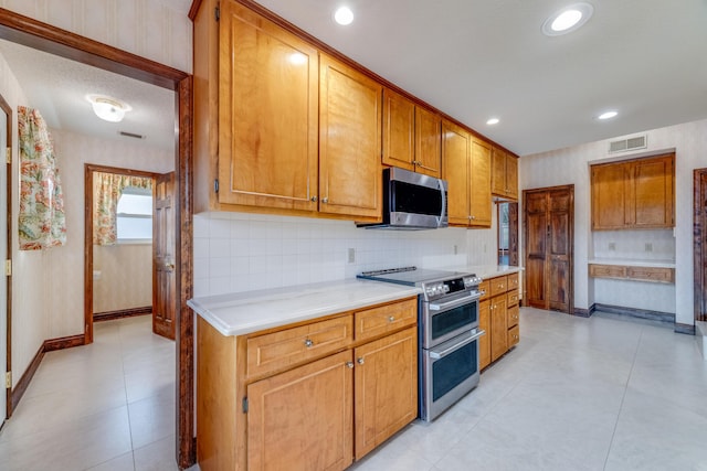 kitchen with appliances with stainless steel finishes and backsplash