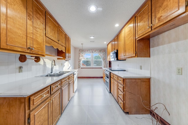 kitchen with stainless steel appliances, decorative backsplash, hanging light fixtures, a textured ceiling, and sink