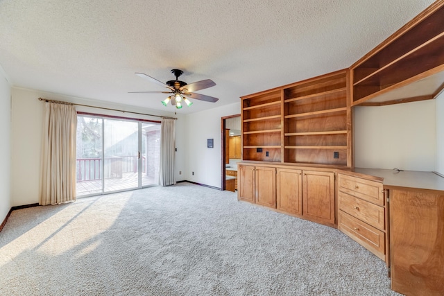 unfurnished living room featuring ceiling fan, light colored carpet, and a textured ceiling