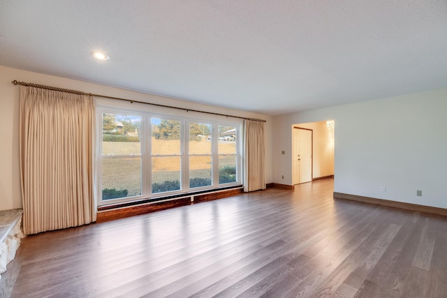 empty room featuring a healthy amount of sunlight and hardwood / wood-style flooring