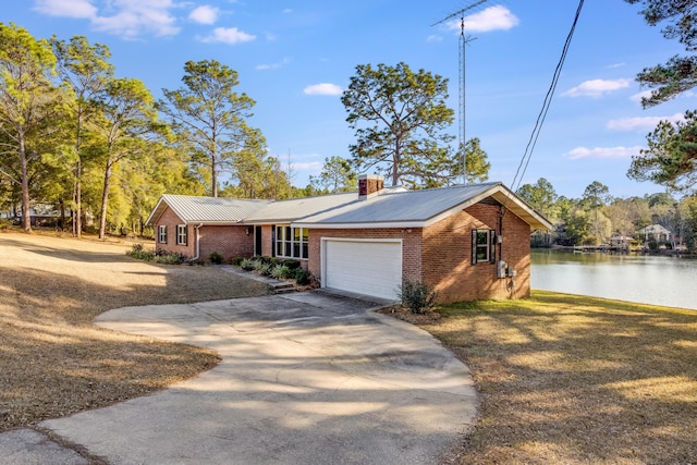 view of front of property featuring a garage and a water view