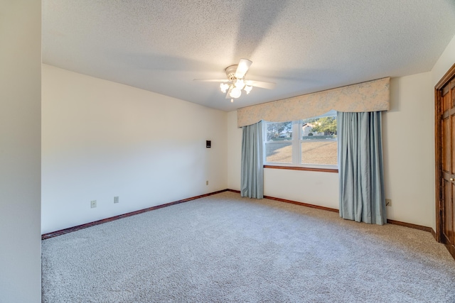 carpeted spare room with ceiling fan and a textured ceiling