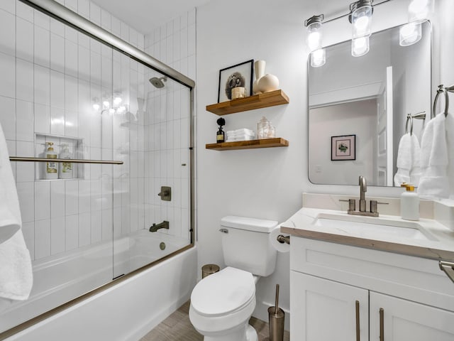 full bathroom featuring shower / bath combination with glass door, vanity, and toilet