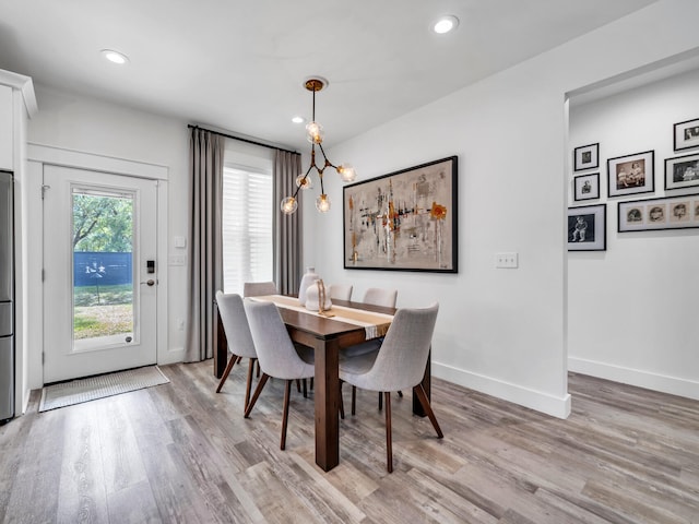 dining space featuring a notable chandelier and light hardwood / wood-style flooring