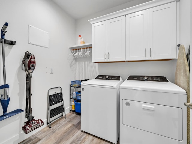 laundry area featuring cabinets, washer and dryer, and light wood-type flooring