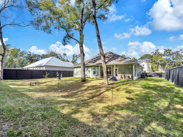 rear view of property with cooling unit and a lawn