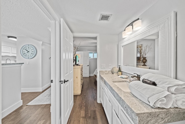 bathroom featuring a textured ceiling, hardwood / wood-style flooring, and vanity