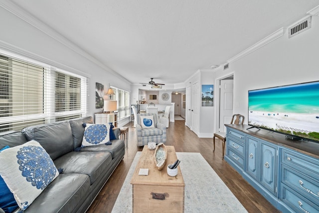 living room with ceiling fan, crown molding, a textured ceiling, and dark hardwood / wood-style flooring