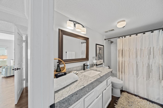 full bathroom with toilet, wood-type flooring, a textured ceiling, shower / bath combination with curtain, and vanity