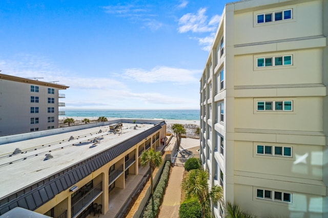 balcony with a water view and a view of the beach