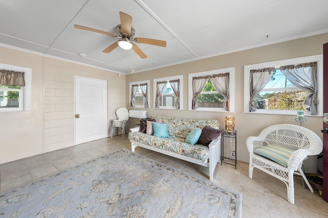 living area with ornamental molding, light tile patterned floors, and ceiling fan