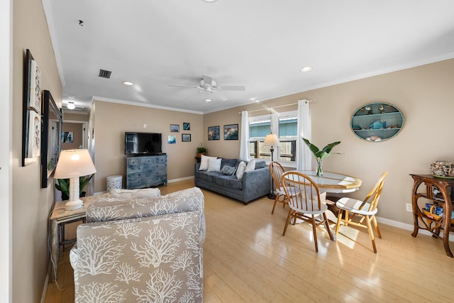 living room featuring crown molding, ceiling fan, and light hardwood / wood-style flooring