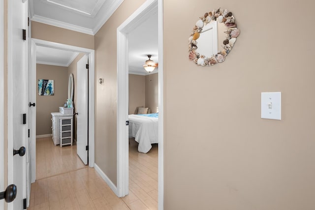 hallway featuring ornamental molding and light hardwood / wood-style floors