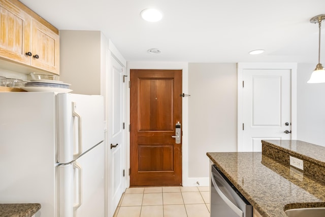 kitchen featuring stainless steel dishwasher, hanging light fixtures, white refrigerator, dark stone counters, and light tile patterned floors