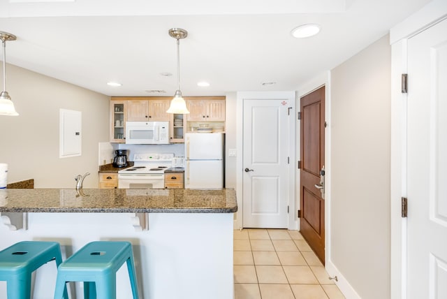 kitchen with pendant lighting, a kitchen breakfast bar, white appliances, and light tile patterned flooring