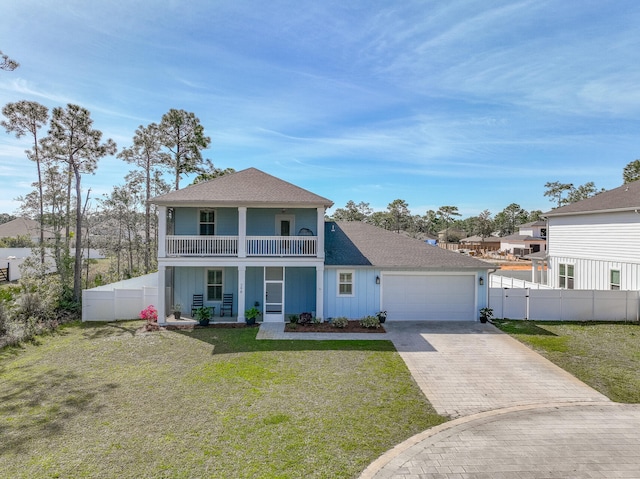 view of front of property with a balcony, a garage, and a front lawn