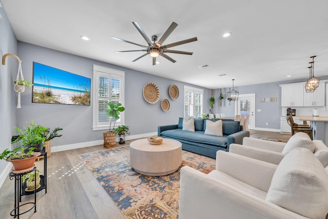 living room with light wood-type flooring and ceiling fan