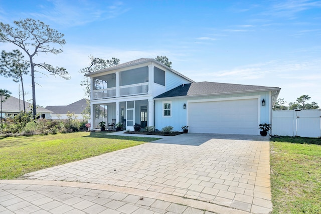 view of front facade with covered porch, a front yard, a balcony, and a garage