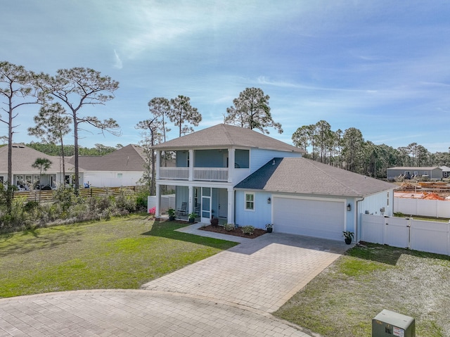 view of front of property with a balcony, a garage, and a front yard