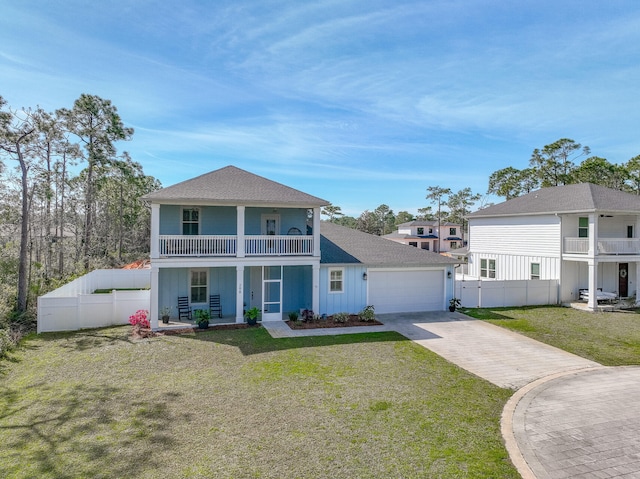 view of front of property featuring a balcony, a garage, and a front yard