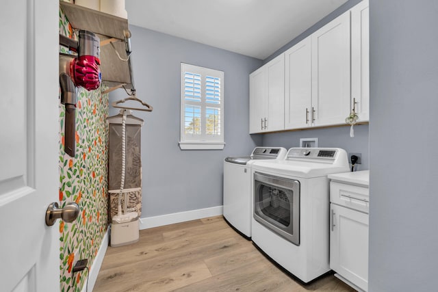 clothes washing area featuring cabinets, light hardwood / wood-style flooring, and independent washer and dryer