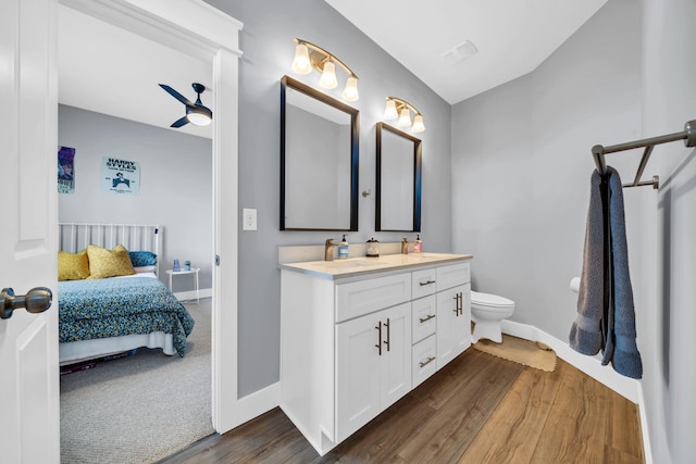 bathroom with wood-type flooring, toilet, ceiling fan, and vanity