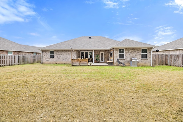 rear view of property featuring a lawn and a patio