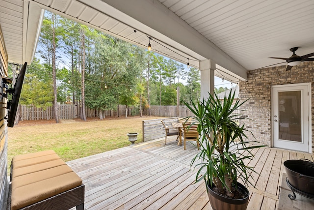 wooden deck with a lawn and ceiling fan