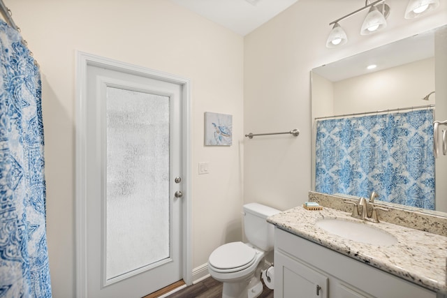 bathroom with hardwood / wood-style flooring, toilet, vanity, and a shower with shower curtain