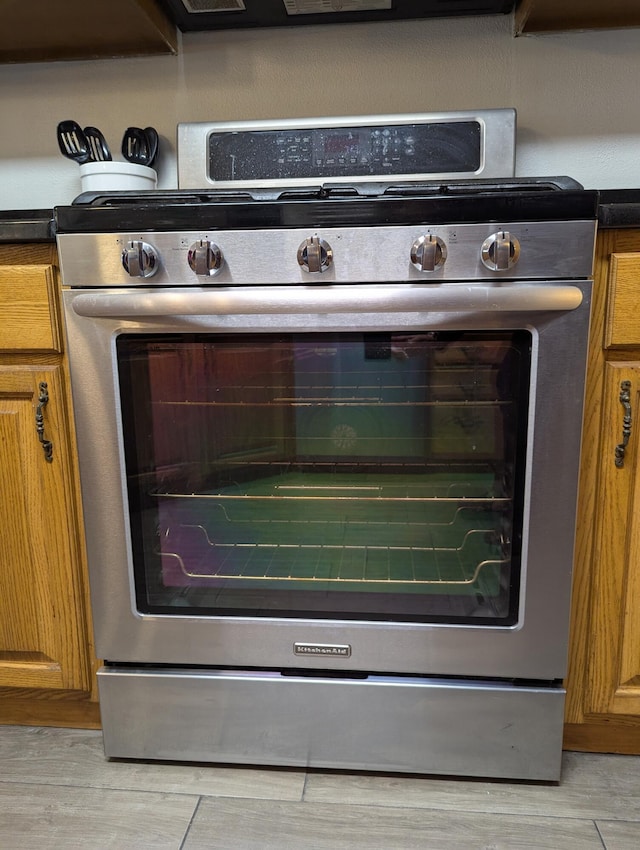 interior details featuring stainless steel gas range and light hardwood / wood-style floors