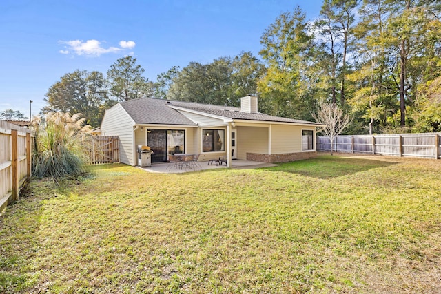 rear view of property featuring a patio area and a lawn