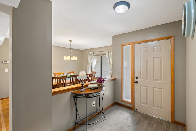 foyer featuring wood-type flooring and a chandelier