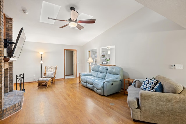 living room featuring lofted ceiling, a brick fireplace, wood-type flooring, and ceiling fan