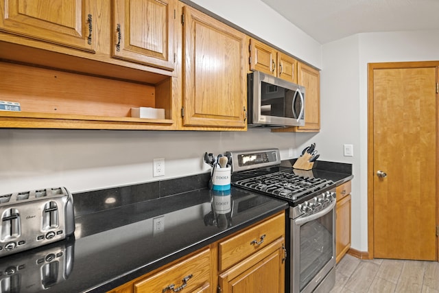 kitchen with light hardwood / wood-style flooring and appliances with stainless steel finishes