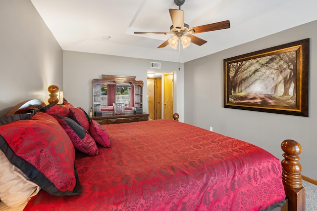 bedroom featuring ceiling fan, a tray ceiling, and carpet floors