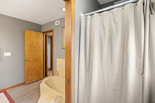 bathroom featuring hardwood / wood-style flooring and a tub