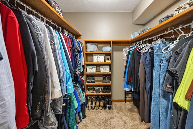 walk in closet featuring light colored carpet