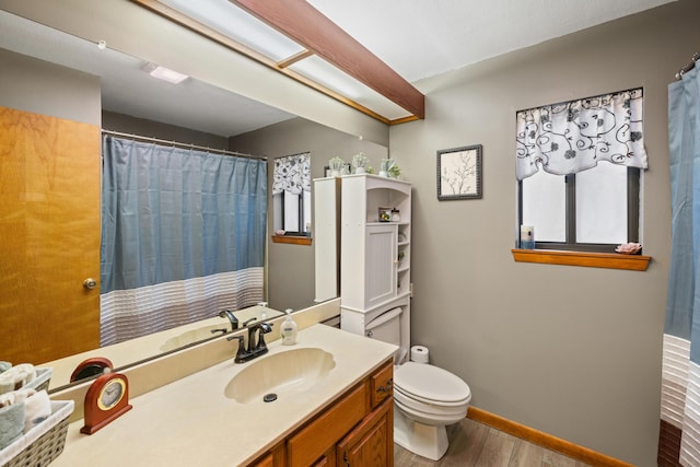 bathroom with hardwood / wood-style flooring, vanity, and toilet